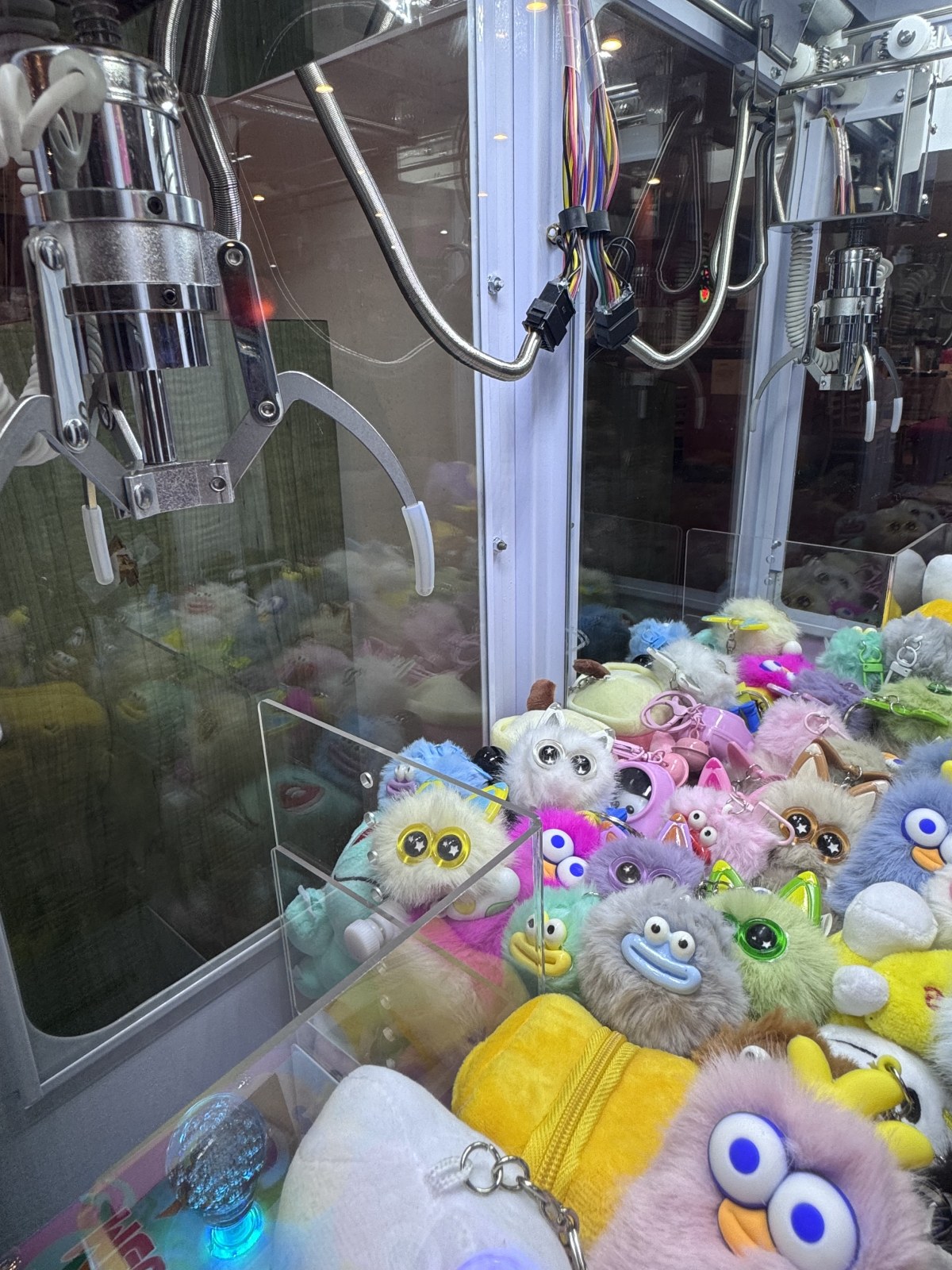Claws, colorful plush prizes, and LED lighting inside the Mega Mini machine